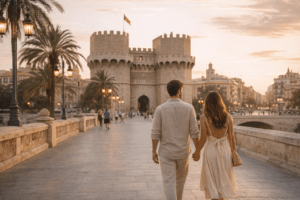 Pareja paseando al atardecer junto a las Torres de Serranos en Valencia durante una escapada de Semana Santa